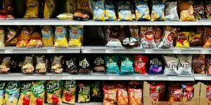 Mit Chips und anderen Süßigkeiten gefüllte Supermarktregale