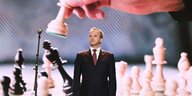 Fide-Präsident Arkadi Dworkowitsch vor einer Leinwand mit überdimensionierten Schachfiguren