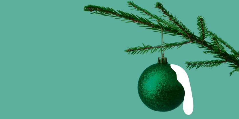 Am Ast eines Tannesbaums hängt eine grüne Christbaumkugel