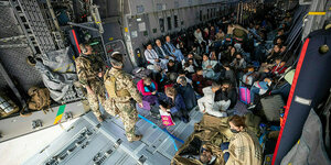 In einem Transportflugzeug der Bundeswehr sitzen Menschen, die von aus Kabul gerettet wurden.