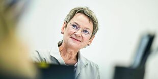 Frauke Gerlach führt ein Gespräch und lächelt leicht