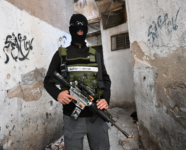 Ein vemummter Mann mit Waffe in der Hand