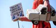 Eine Frauen-Figur mit einem Pick-Up unter dem Arm und einem Schild mit der Aufschrift "Rechte nichts steuern lassen" wird in der Demonstration geschoben.