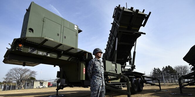 Ein japanischer Soldat steht vor einem Raketenabwehrsystem