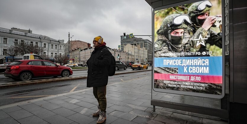 An einer Bushaltstelle in Moskau ist ein Werbeplakat für das russische Militär angebracht