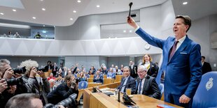 Martin Bosma steht mit Hammer in der Hand und freut sich, während Pressefotografen ihn fotografieren