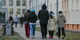 Menschen gehen über das Gelände der Zentralen Erstaufnahmeeinrichtung für Asylbewerber