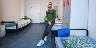 Eine Frau steht im Zimmer einer Notunterkunft mit mehreren Betten