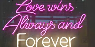 In einem Schaufenster Hängt eine Leuchtreklame und darauf steht: Love Wins Always and forever