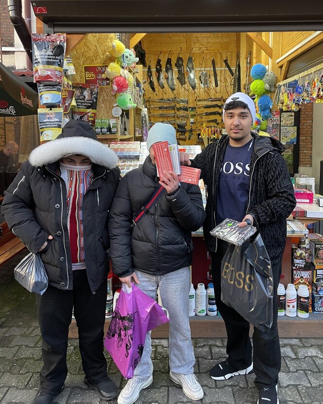 Drei Jugendliche stehen vor einem Stand