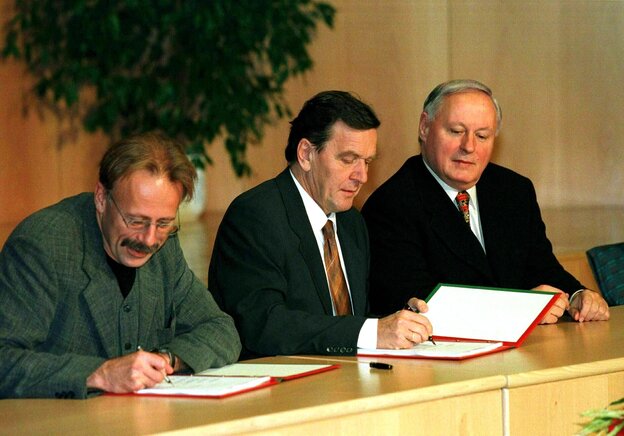 Jürgen Trittin unterschreibt den Koalitionsvertrag, neben ihm sitzen Gerhard Schröder und Oskar Lafontaine