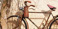 Eine alte, rostige Milchkanne hängt an einem Fahrradlenker