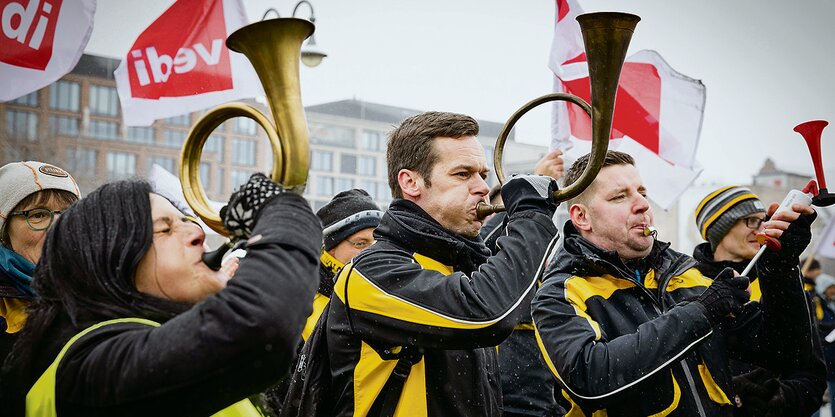 Bei einem Verdi-Streik blasen Protestierende in Hörner