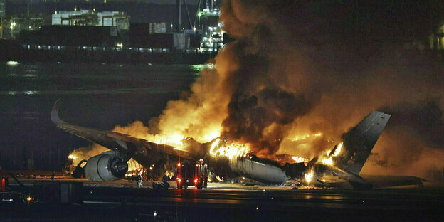 Ein brennendes Flugzeug bei Nacht