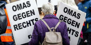 Eine Demonstrantin von Omas gegen Rechts mit Schildern.