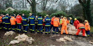 Einsatzkräfte des Technischen Hilfswerks (THW) sind im Einsatz, um ein Wohnhaus am Osternburger Kanal vor dem drohenden Hochwasser mit Sandsäcken zu sichern