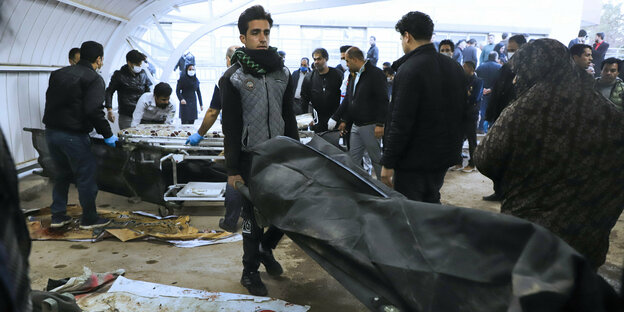 Ein Mann trägt die Leiche eines Opfers nach zwei Explosionen in der iranischen Stadt Kerman 820 Kilometer südöstlich von Teheran