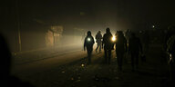 Bewohner eines provisorischen Zeltlagers in Gaza gehen mit Taschenlampen durch die Dunkelheit