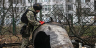 Ein Mann arbeitet an einem Teil einer russischen Rakete, die mitten in einer Wohnsiedlung liegt.