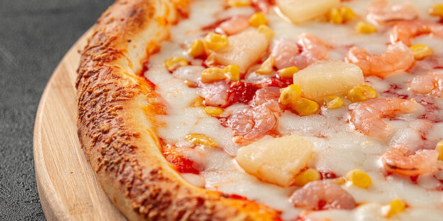Eine frische Hawaii-Pizza mit Ananas und Schinken.