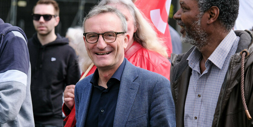 Thomas Geisel lacht in mitten einer Demonstration.