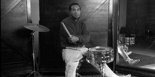 Der Schlagzeuger Max Roach sitzt an seinem Instrument.