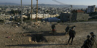 Blick von einer Anhöhe aus auf Dschenin, im Vordergrund ist ein Loch in der Straße zu sehen, wo eine Bombe explodiert sein soll
