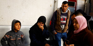Eine trauernde Frau mit Kopftuch, um sie herum weitere Palästinenser.
