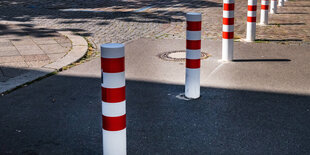 Weiß rote Poller zur Verkehrsberuhigung stehen auf einer Straße