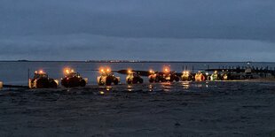 Mehrere Trecker auf einer Straße vor der Nordsee