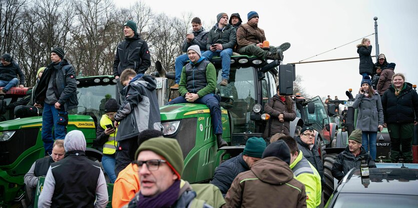 Menschenmasse um Traktoren und Autos geschart.