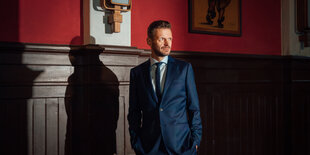 Der Satiriker Florian Schroeder vor einer Wand in Clärchens Ballhaus in Berlin