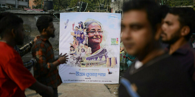 Männer hlten ein Wahlplakt mit dem Konterfei von Sheikh Hasina