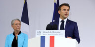 Präsident Macron steht an einem Redepult, hinter ihm Elisabeth Borne und französische Flaggen im Juli 2023