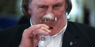 Depardieu hat seine nase in ein Weinglas gesteckt