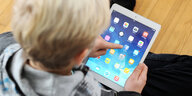 Ein Kind klickt auf das Facebook-Icon auf seinem iPad.