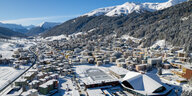 Luftaufnahme des Schweizer Bergorts Davos mit verschneiten Gipfeln im Hintergrund