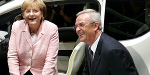Merkel sitzt in einem Auto, Winterkorn kniet vor ihr