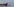 Detail eines Containerschiffs und ein Lotsenboot