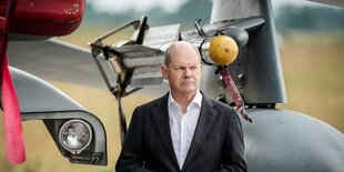 Olaf SCholz steht neben einem IRIS-T Luft-Luft_Lenkflugkörper der Bundeswehr