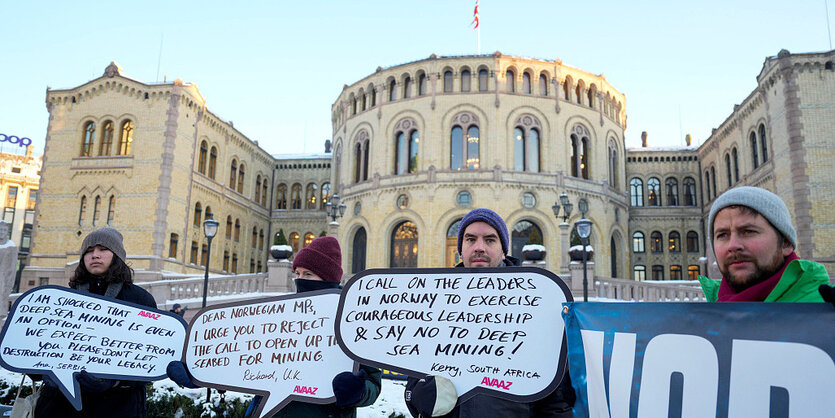 Menschen halten Transparente in Form von Sprechblasen