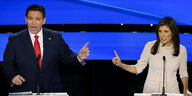Ron DeSantis und Nikki Haley zeigen auf einer Bühne gegenseitig mit dem Finger aufeinander