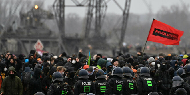 Demonstranten stehen der Polizei in Lützerath gegenüber. Der Energiekonzern RWE will die unter Lützerath liegende Kohle abbaggern - dafür soll der Weiler auf dem Gebiet der Stadt Erkelenz am Braunkohletagebau Garzweiler II abgerissen werden.