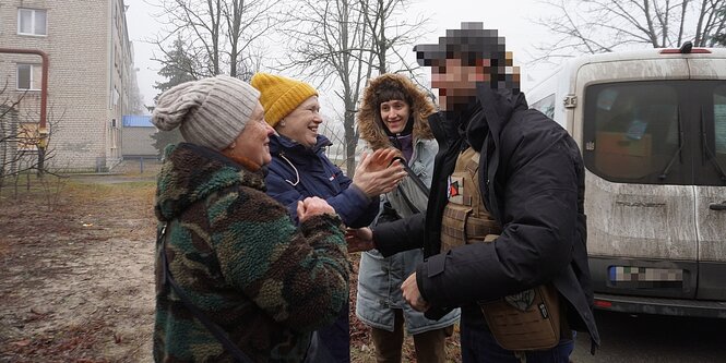 Vier Personen begrüßen sich herzlich.