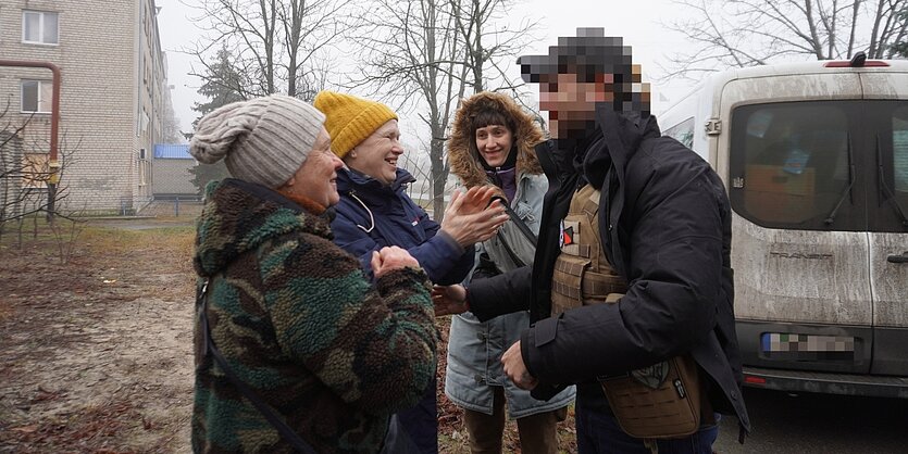 Vier Personen begrüßen sich herzlich.