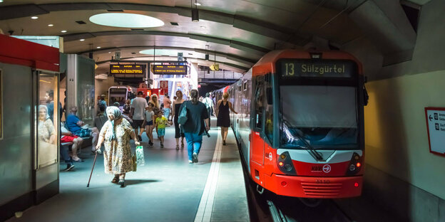 Untergrundhaltestelle einer Straßenbahn, mehrere Menschen auf dem Bahnsteig. Auf der Bahnlinie 13 der Kölner Verkehrsbetriebe AG steht die Endhaltestelle "Sülzgürtel".