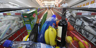 Ein mit Waren gefüllter Einkaufswagen in einem Supermarkt.