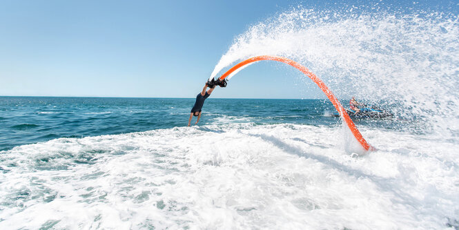 Eine Person auf einem Flyboard hechtet ins Wasser.