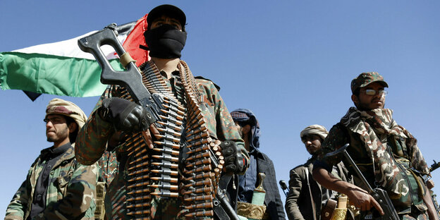 Martialisches Auftreten von Huthi-Rebellen mit Gesichtsmaske, Maschinengewehr und Munitionsgürtel um den Hals