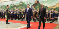 Der maledivische und der chinesische Präsident laufen auf einem roten Teppich vor einer Militärformation